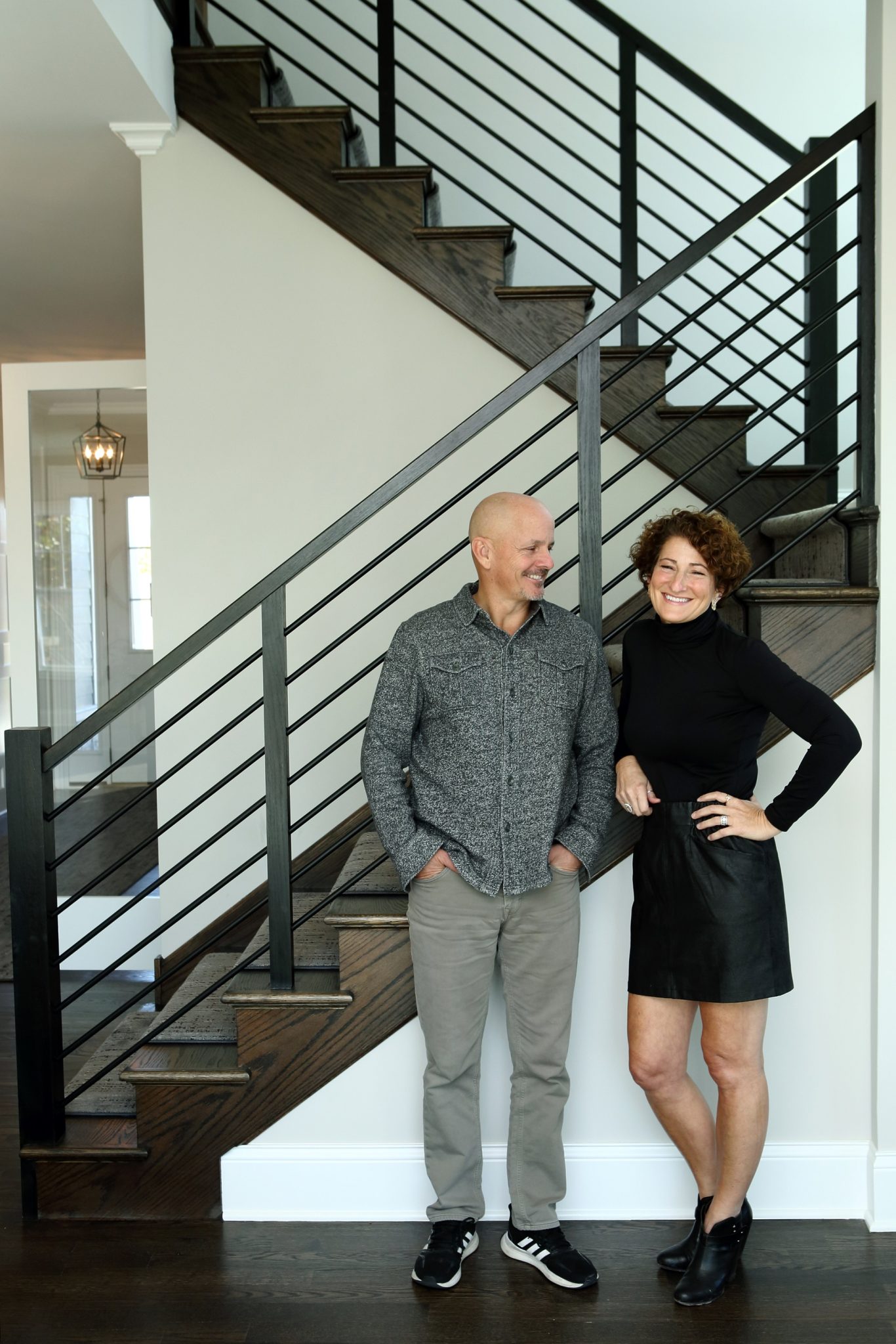 Charlie and Jenny at the foot of a staircase in an Icon custom home
